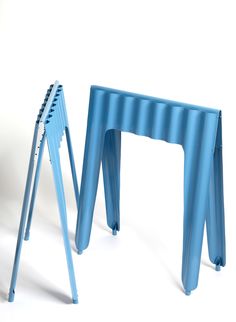 two blue stools sitting next to each other on a white surface with one standing up