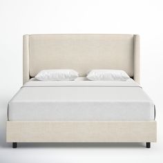 a bed with white linens and pillows on it's headboard is shown