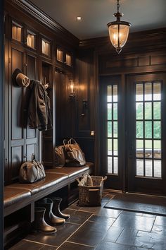 an entryway with wooden paneling and leather bags hanging on the wall next to it