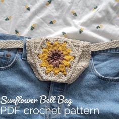 a crocheted sunflower bell bag on top of a pair of jeans