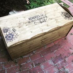 a wooden box sitting on top of a brick sidewalk