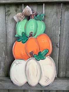 a painting of pumpkins and squash hanging on a fence