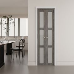 an empty kitchen with chairs and a table in front of the door that leads to another room