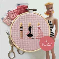 there is a doll next to a cross - stitch pattern with scissors and thread on it