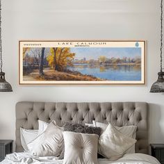 a bedroom with a large painting on the wall above it's headboard and pillows