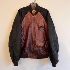 Fantastic Vintage Harley Davidson Jacket From The 1980s! Heavy Duty Brown Leather Motorcycle Bomber With Black Windbreaker Sleeves And Brown Ribbed Stretch-Knit Cuffs And Collar. The Details On This Coat Are Beautiful From The Logo Zipper Pull, To The Vintage Photo On The Interior Lining, To The Metal Hog Member’s Tag (Unused). The Leather Is High Quality, Soft And Supple, And The Weight And Warmth Of The Jacket Is Substantial Without Feeling Too Fussy Or Stuffy. Styling Is Gender Neutral And Ca Vintage Brown Outerwear For Winter Streetwear, Vintage Brown Fall Outerwear For Streetwear, Vintage Brown Fall Streetwear Outerwear, Retro Black Leather Jacket With Pockets, Vintage Brown Leather Jacket For Streetwear, 90s Style Brown Long Sleeve Outerwear, 90s Brown Long Sleeve Outerwear, 90s Brown Winter Outerwear, Harley Davidson Jacket