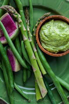 asparagus, watermelon and guacamole on a green plate