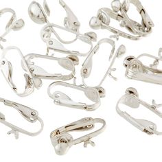 several pairs of silver metal clips on a white background