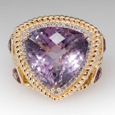 This stunning cocktail ring features a large triangular amethyst center stone with a checkerboard top. The amethyst is surrounded by a diamond halo and each side of the ring is bezel set with two triangular cut smaller amethysts. The ring is accented with rope detailing and is currently a size 7.25. We offer complimentary resizing. Amethyst Jewellery, Antique Cocktail Ring, Vintage Spoon Rings, Amethyst Rings, Amethyst Cocktail Ring, High Jewellery, Light Amethyst, Precious Jewels, Diamond Cocktail Rings