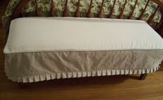 a wooden bed frame with white sheets on it