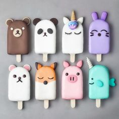 several pops with different types of ice cream on top of each other, including unicorns and bears