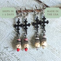 These Cross Earrings feature a rustic medieval design, perfect for adding a touch of artisanal charm. With lever back closures, they make an elegant Christian religious jewelry gift for your wife or a thoughtful stocking stuffer for your mom. 𝗗𝗘𝗧𝗔𝗜𝗟𝗦 🍃 Earrings measure 1 and 3/4 inches from base of ear wires 🍃 Ear wires made in the USA of lead/nickel free antiqued silver plated brass 🍃 Rustic black pewter cross charms 🍃 Finely detailed brass and pewter; black and antiqued silver plated 🍃 Swarovski crystal, carved bone, and handmade paper beads 🍃 One of a kind gift; don't miss out! 𝗖𝗢𝗟𝗢𝗥 𝗢𝗣𝗧𝗜𝗢𝗡𝗦 1) red opaque Swarovski crystal 2) gray opal Swarovski crystal 𝗛𝗢𝗪 𝗧𝗢 𝗢𝗥𝗗𝗘𝗥 1: Select item quantity 2: Select options, if applicable 3: Add to cart 4: Choose shipp Handmade Adjustable Medieval Jewelry, Handmade Medieval Cross Jewelry, Adjustable Handmade Medieval Jewelry, Medieval Style Handmade Earrings For Gift, Handmade Bohemian Cross Jewelry, Handmade Medieval Jewelry For Gift, Handmade Medieval Jewelry As Gift, Handmade Medieval Style Jewelry For Gift, Handmade Medieval Jewelry As A Gift