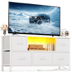 a large television mounted on top of a white cabinet