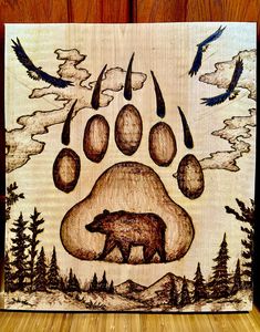 a bear's paw is shown on a wooden plaque