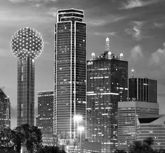 black and white photograph of the city skyline at night with tall buildings in the foreground