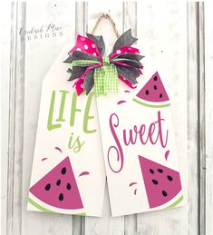 two watermelon gift tags hanging on a white wooden door with the words life is sweet