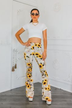 "Leave a love letter in every step with these buttery soft Sunflower Bell Bottom Pants. Flowing like a love letter, these pants offer unmatched comfort and style. Spread love with every wear. Spread good vibes (and fashion) with these bell bottoms!" Model is 5”4 and wearing 5 inch heels: wearing a size small. Great stretch. Trendy White Floral Print Pants, Trendy Printed Bottoms With Relaxed Fit, Trendy Relaxed Fit Printed Bottoms, Floral Print High-waisted Lounge Pants, Casual Stretch Bottoms With Floral Print, High Waist Floral Print Bottoms For Loungewear, High Waist Floral Print Loungewear Bottoms, Trendy Stretch Bottoms With Floral Print, Trendy Long Bottoms With Floral Print