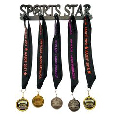 four medals hanging from a metal rack with the words sports star written on each medal