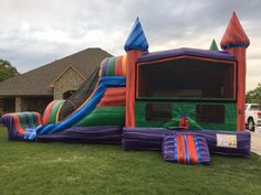 an inflatable bounce house with slide on the lawn