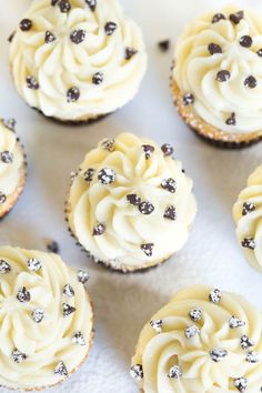 several cupcakes with white frosting and chocolate chips