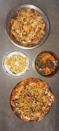 three pizzas sitting on top of pans covered in cheese and other toppings