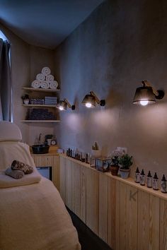 a room that has some lights on the wall and towels on the shelves in front of it