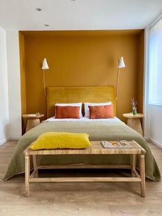 a bedroom with orange walls and a bed in the middle, along with two nightstands on either side