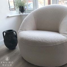 a large white chair sitting in front of a window