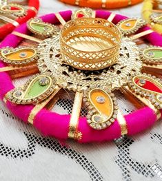 several different colored necklaces sitting on top of a white lace tablecloth with beads