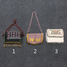 three different purses are shown on a gray surface, one with fringe and the other with beading