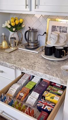 an open drawer in a kitchen filled with tea and coffee