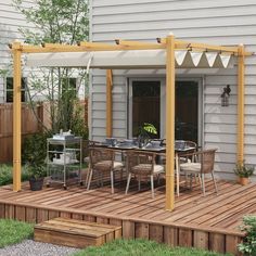 an outdoor dining area with wooden decking and white awning