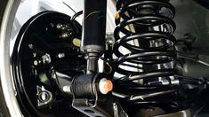 the front end of a motorcycle with springs attached to it's rear suspensions