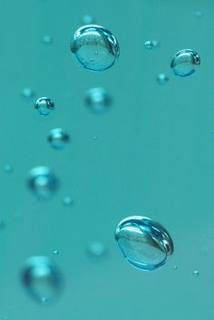 water bubbles floating in the air on a blue surface