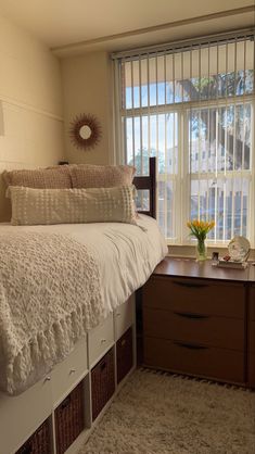 a bedroom with a bed, dresser and window