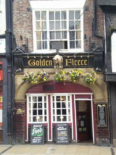 an old brick building with flowers on the outside