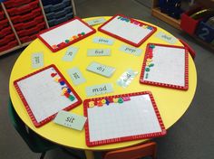 a yellow table topped with lots of placemats and magnets on top of it