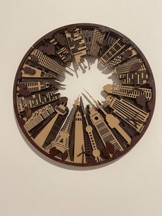 a clock that is on the side of a wall with buildings and people in it