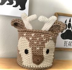 a crocheted deer basket sitting on top of a wooden table