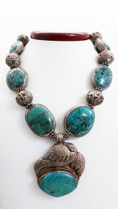 "Handmade Reversible Sterling Silver Tibetan Bird Pendant Necklace w/ Silver Wrapped Turquoise Stones & Nepalese Silver Beads with Coral and Turquoise Inlay. The beautiful sterling silver wrapped stones in this necklace are turquoise. These beads were hand-crafted in Nepal, likely by Tibetan refugees. Turquoise has been a treasured jewelry stone around the world for thousands of years. It was used by the Egyptians as early as 5500 B.C. In many cultures, turquoise is regarded as a harbinger o Traditional Turquoise Pendant Necklace With Polished Beads, Traditional Turquoise Jewelry With Large Pendant, Traditional Turquoise Jewelry With Natural Stones, Turquoise Amulet Style Jewelry With Polished Beads, Turquoise Amulet Jewelry With Polished Beads, Traditional Turquoise Pendant Necklace With Gemstone Beads, Turquoise Polished Beads Amulet Jewelry, Traditional Silver Turquoise Necklace With Large Pendant, Traditional Blue Turquoise Necklace With Large Pendant