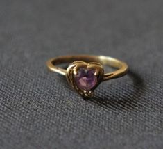 Vintage ring with the Amethyst / diamond in the  center. The Amethyst and Diamond are natural and not enhanced in any way!  This ring feature a 6mm amethyst and a white 1mm diamond set on a 10K solid gold  band. This ring stands out by it self or it is beautiful stacked with others rings.   Ring is a finger size between 6 and 7. The ring is made of 10 karat gold. The hallmarks are 10 KT Heart-shaped Amethyst Ring With Accent Stones, Heart-shaped Amethyst Ring With Center Stone As A Gift, Heart Cut Amethyst Ring With Accent Stones For Anniversary, Heart-shaped Amethyst Ring For Anniversary, Heart Shaped Amethyst Ring With Center Stone As Gift, Heart-shaped Amethyst Ring With Center Stone For Gift, Amethyst Heart Cut Ring For Anniversary, Heart-shaped Purple Amethyst Promise Ring, Purple Heart Amethyst Ring With Accent Stones