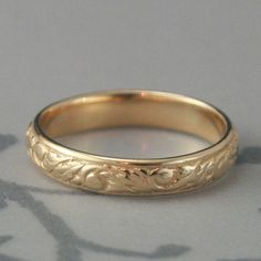 This is a lovely lovely band! Featuring a swirl and leaf pattern, it is cast in solid 14K Yellow gold. The final band measures 3mm wide by just over 1mm thick, a very nice weight for a wedding band or everyday ring. This is possibly one of my very favorites and I'm certain you will love it as well. Care to add a personalized message engraved inside this ring? Click here: https://www.etsy.com/listing/207396292/ For this ring in Rose gold: https://www.etsy.com/listing/121697905 For this ring in Wh Classic Engraved Band Ring For Wedding, Engraved Round Band Couple Rings For Wedding, Elegant Marriage Band Jewelry, Elegant Engraved Band Ring For Anniversary, Engraved Round Band For Wedding, Wedding Engraved Ring With Decorative Band, Engraved Wedding Band Rings, Engraved Round Wedding Band, Ornate Yellow Gold Engraved Ring For Wedding