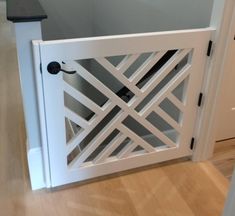 an open white door on the inside of a house with wood floors and walls in front of it