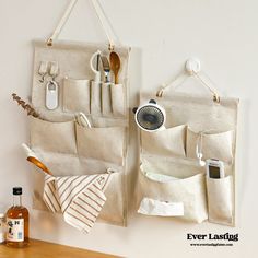 there are two hanging pockets on the wall with utensils and other items in them