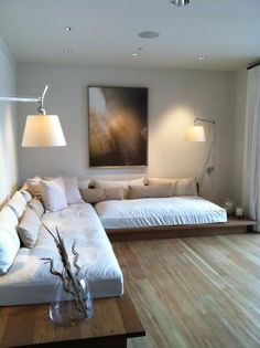 a living room filled with furniture and a large painting on the wall above it's headboard