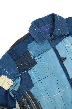 a blue and black patchwork shirt sitting on top of a white surface