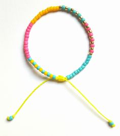 the colorful bracelet is made with beads and string, which are attached to an adjustable cord