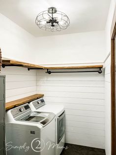 a washer and dryer in a laundry room with white shiplap walls