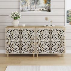 the sideboard is decorated with white flowers and an art work on the wall behind it