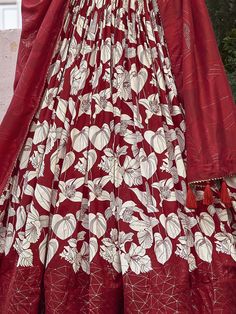 The red color tussar silk lehenga with floral and foil print work is a captivating ensemble that embodies both tradition and modernity. This semi-stitched lehenga, designed to fit up to 42 inches, boasts a luxurious 3.80-meter flair, providing a dramatic and elegant silhouette. The 42-inch length ensures the lehenga drapes beautifully, creating a striking visual impact. Accompanied by an unstitched choli with 0.80-meter material, this outfit allows for a tailored fit, enhancing both comfort and Red Floor-length Sharara With Zari Work, Festive Floor-length Palazzo Set With Printed Motifs, Semi-stitched Red Palazzo Set For Festivals, Festival Lehenga With Printed Motifs And Straight Kurta, Festive Sharara With Traditional Drape And Printed Motifs, Traditional Drape Sharara With Printed Motifs For Diwali, Unstitched Floor-length Anarkali Set For Traditional Ceremonies, Unstitched Floor-length Anarkali Set For Ceremonies, Unstitched Anarkali Set For Traditional Ceremonies